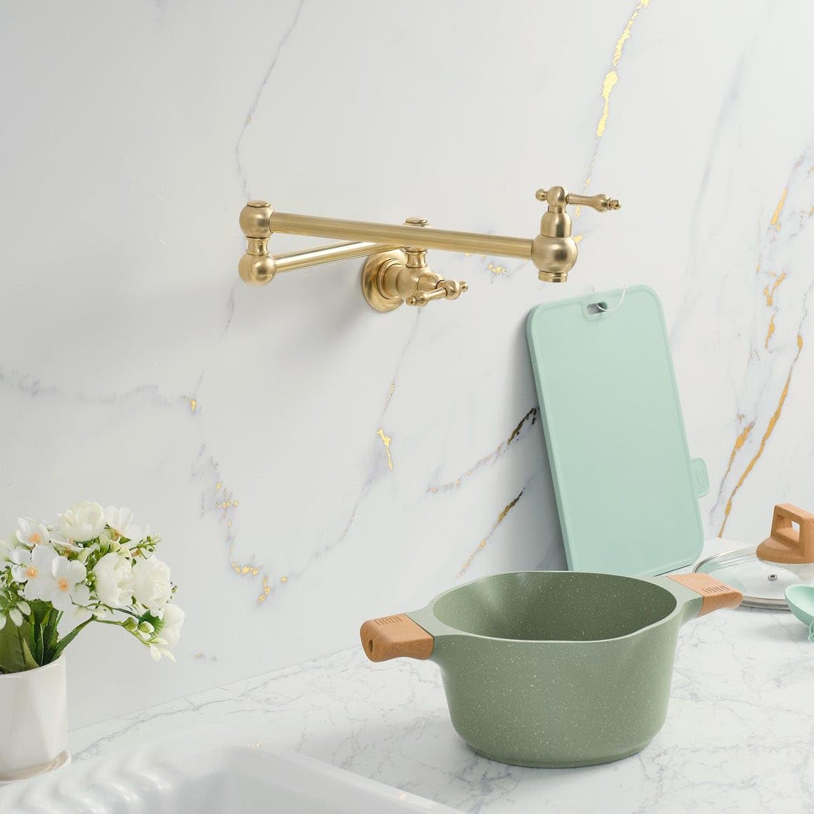 Dual-jointed unlacquered brass pot filler articulating over a luxury cooktop range. Hand-cast virgin binary alloy.