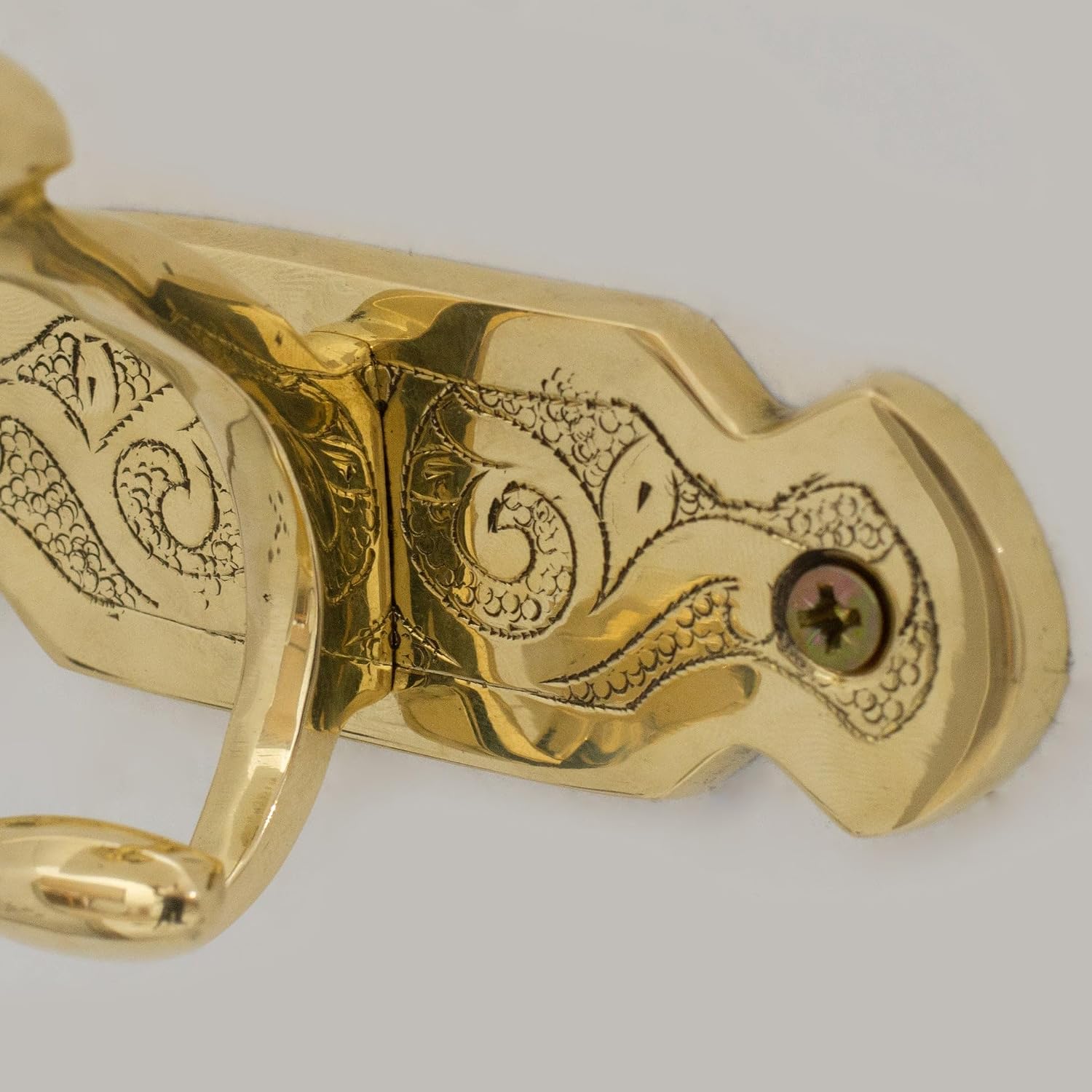 Hand-chiseled arabesque detail on unlacquered brass coat hook - Detail Close-up